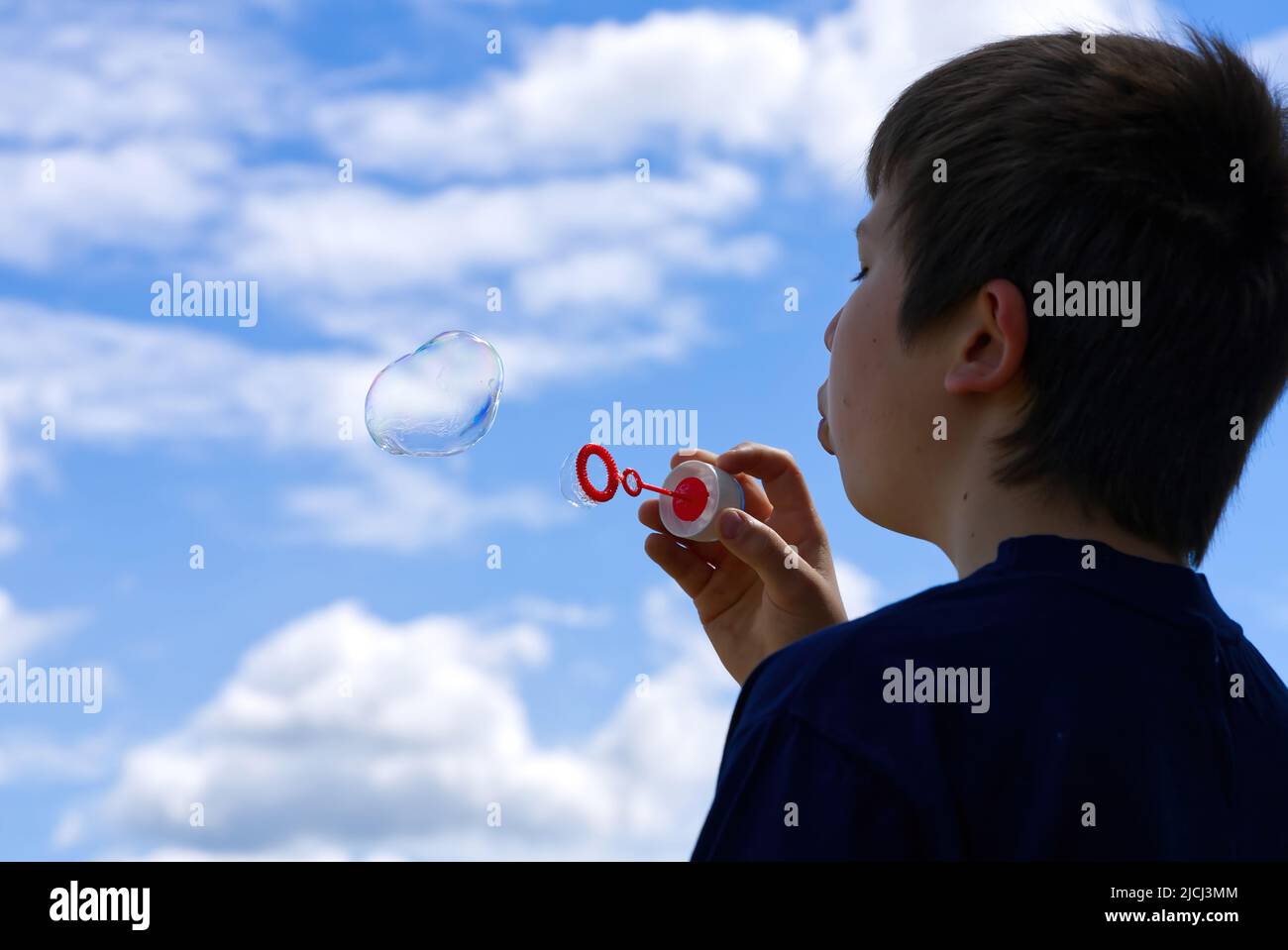 Il bambino soffia bolle di sapone in natura. Foto Stock