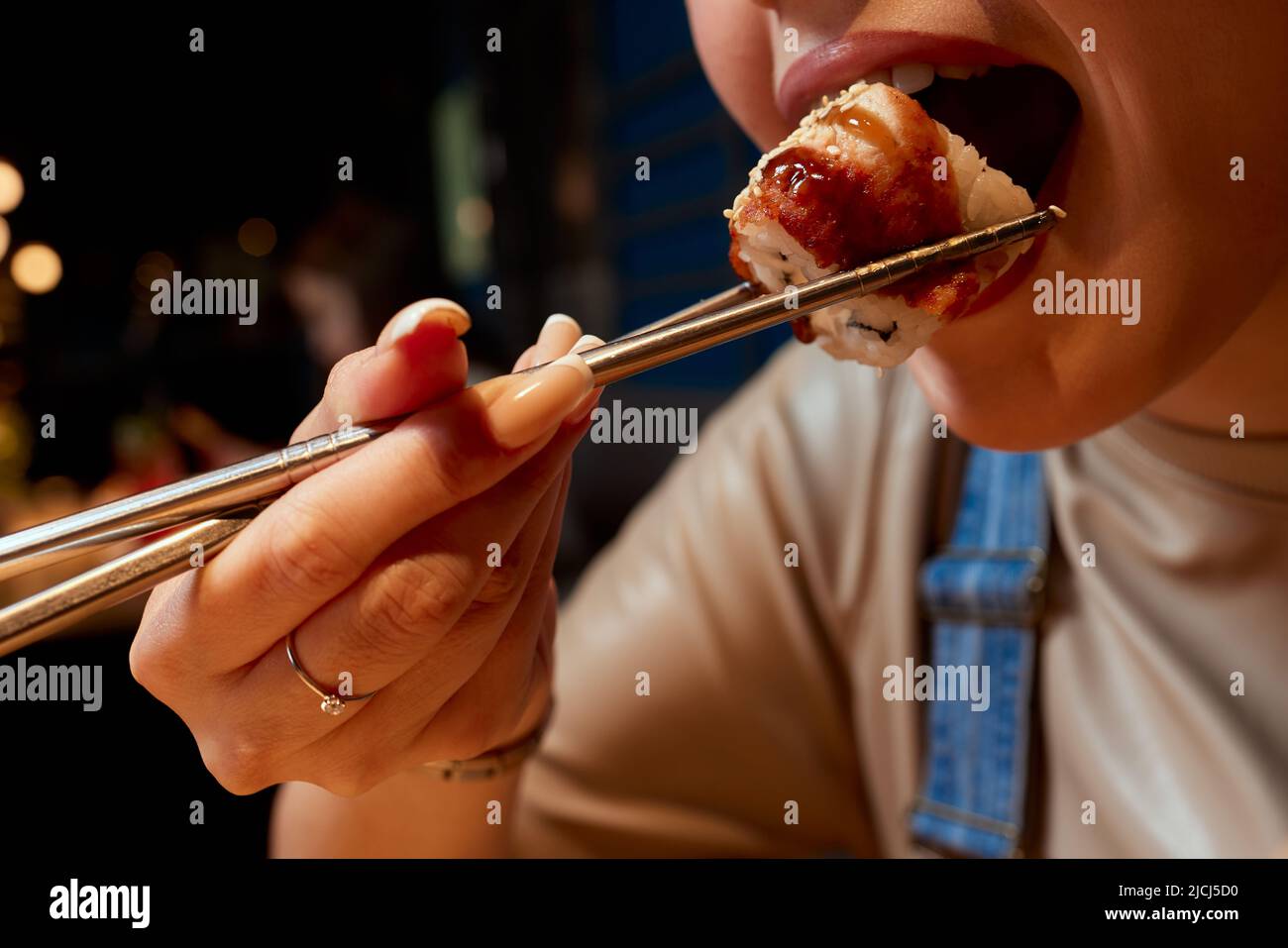Giovane donna corto 20s indossare abiti casual tenere in mano makizushi sushi rotolo servito su piatto tradizionale cibo giapponese Foto Stock