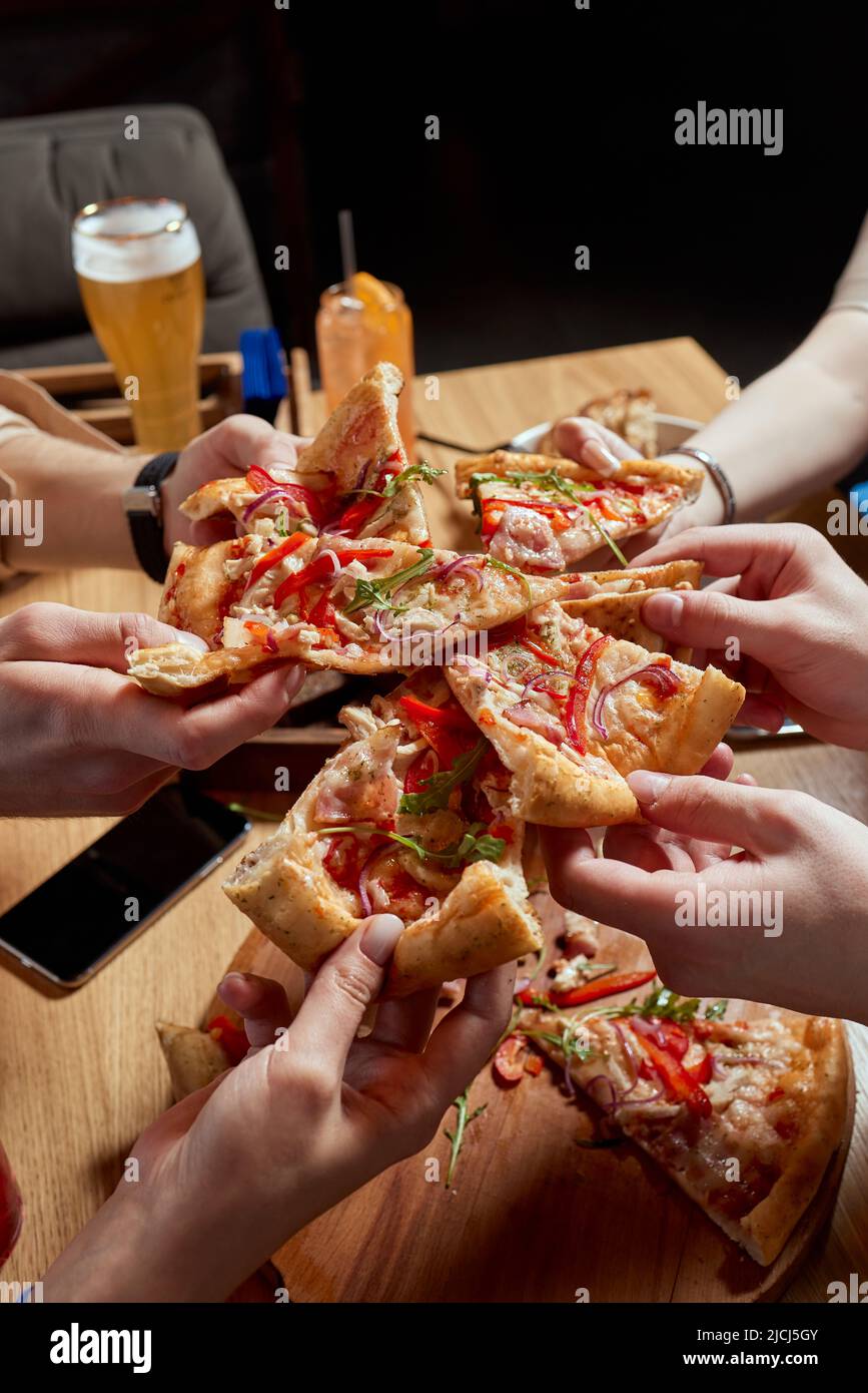Immagine di amici adolescenti mani prendendo fette di pizza Foto Stock