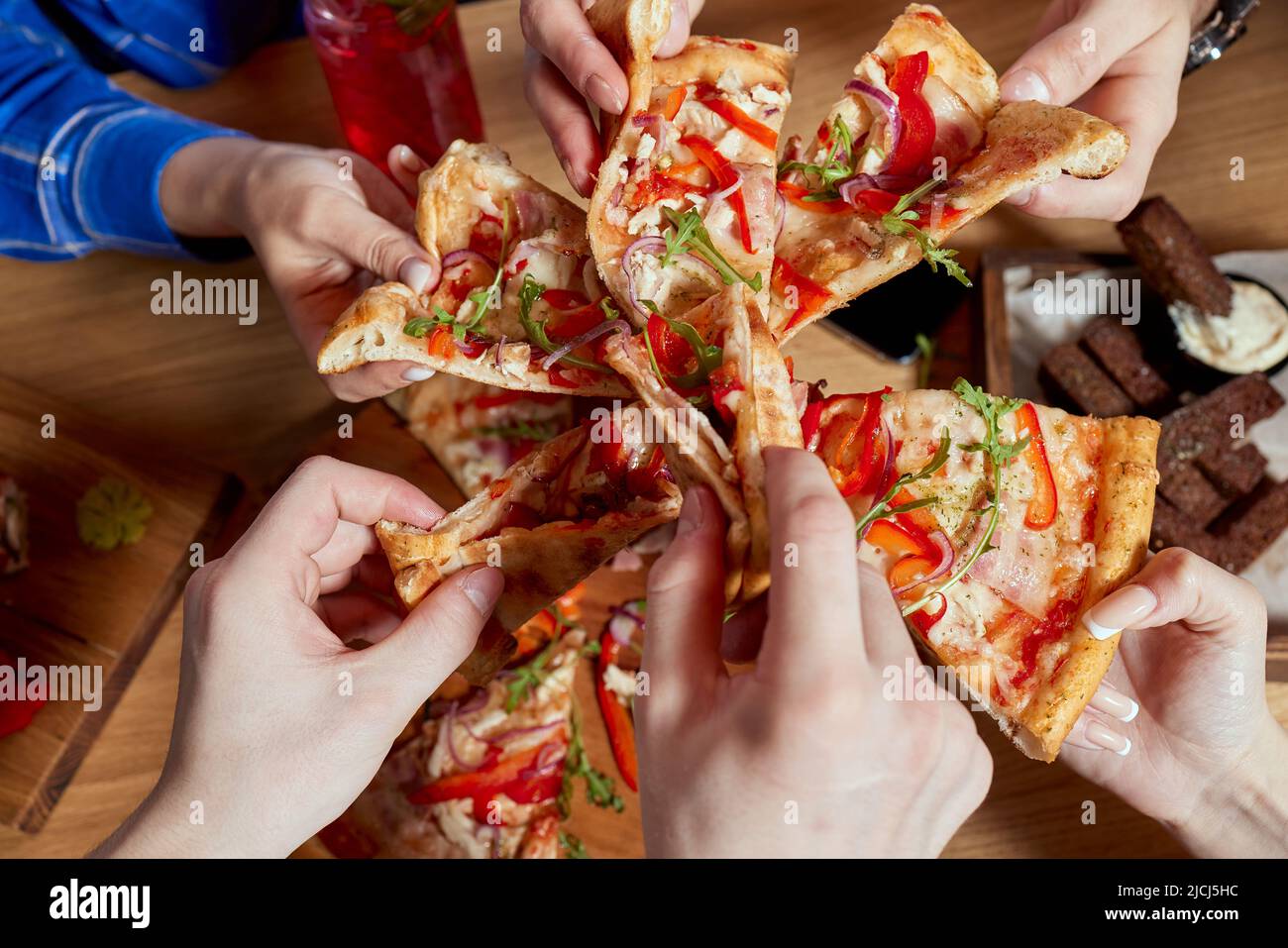 Immagine di amici adolescenti mani prendendo fette di pizza Foto Stock