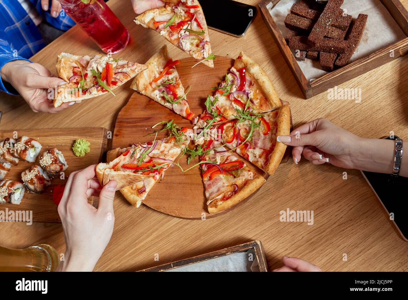 Immagine di amici adolescenti mani prendendo fette di pizza Foto Stock