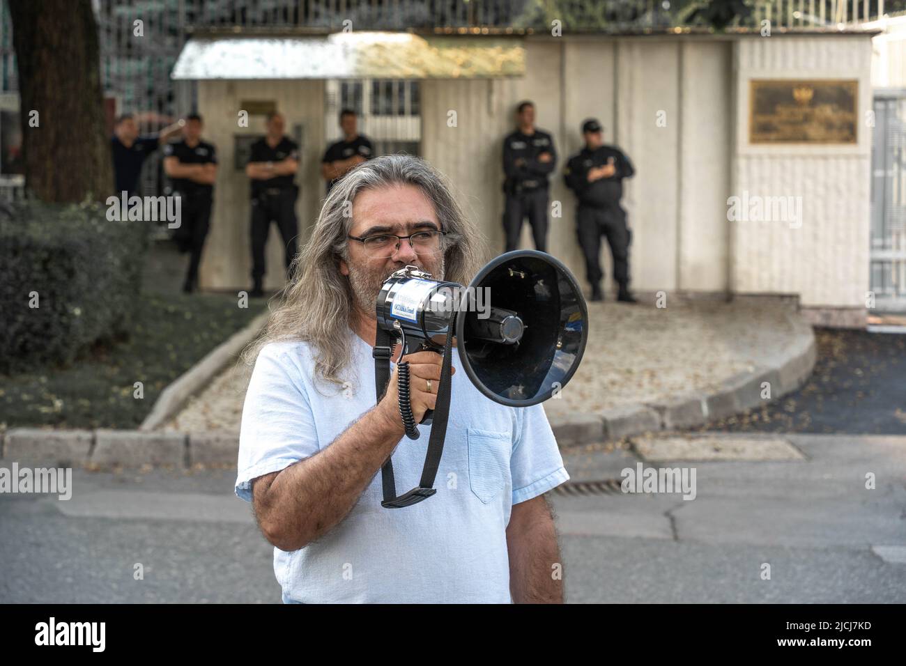 Sofia, Bulgaria, 13 giugno 2022: Un uomo con un altoparlante dà un discorso allo Stand con l'Ucraina incontro con uno sfondo degli ufficiali di polizia gua Foto Stock