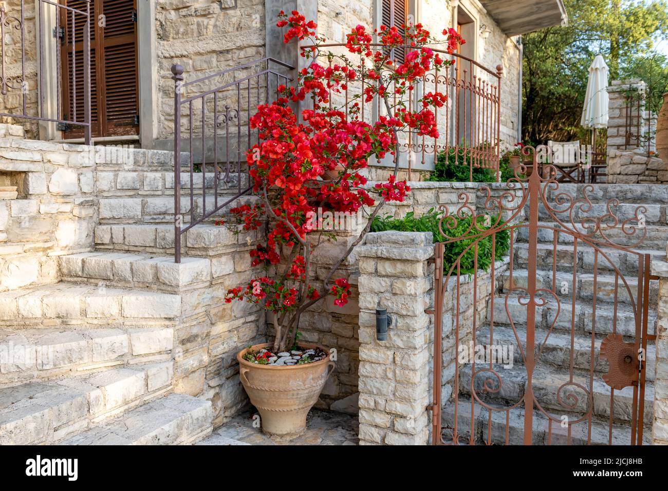 Una bella casa in pietra in stile tradizionale sull'Isola di Ithaca, Grecia, decorata con piante di pentola. Foto Stock