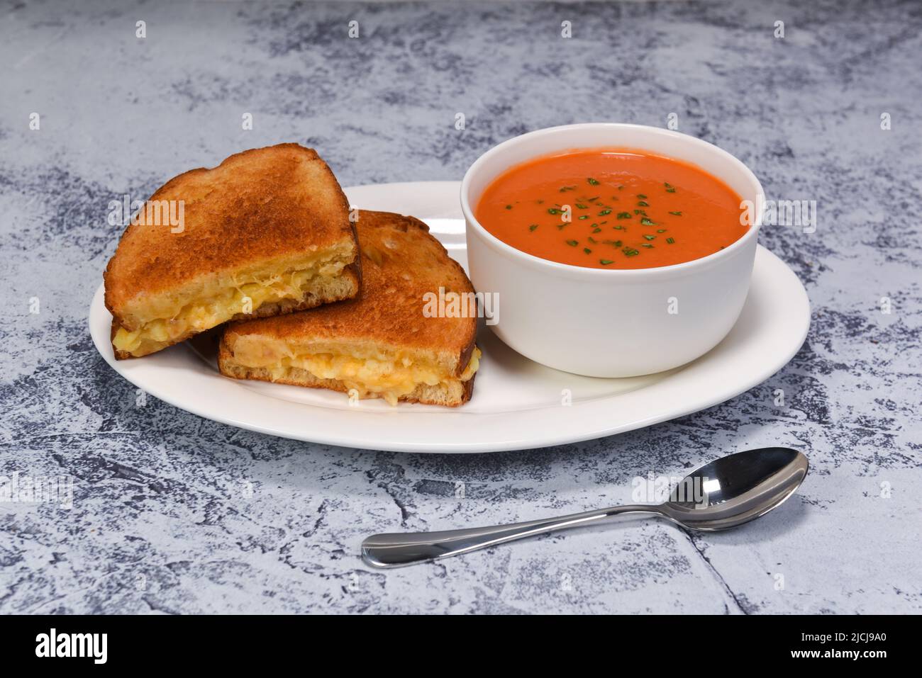 Un croccante sandwich di formaggio alla griglia con un lato di gustosa zuppa di pomodoro. Foto Stock
