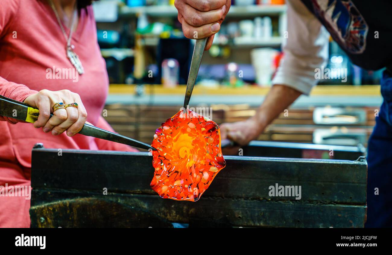 Fare un fiore di vetro in un laboratorio di soffiatura del vetro Foto Stock