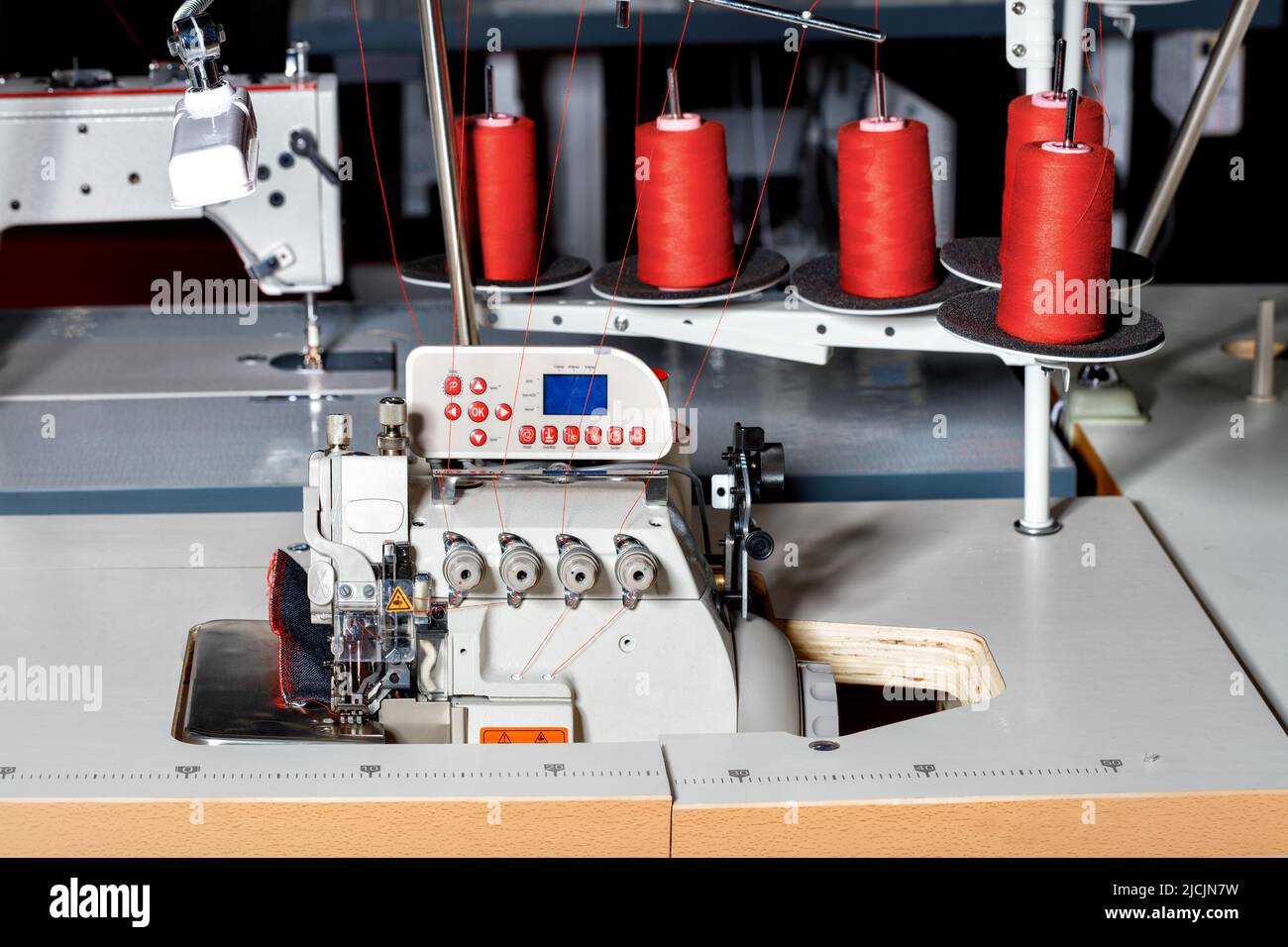 Tre bobine in plastica trasparente per macchina da cucire. Industria  tessile. Dettaglio delle attrezzature per cucire. Sfondo rosso,  retroilluminazione Foto stock - Alamy