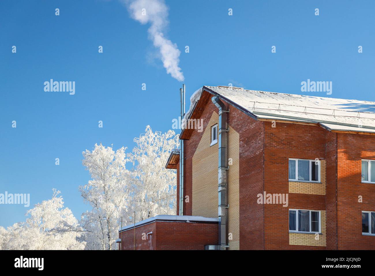 Fumo dal camino di una casa privata con il proprio locale caldaia. Gelo freddo inverno. Specifico per la stagione Foto Stock