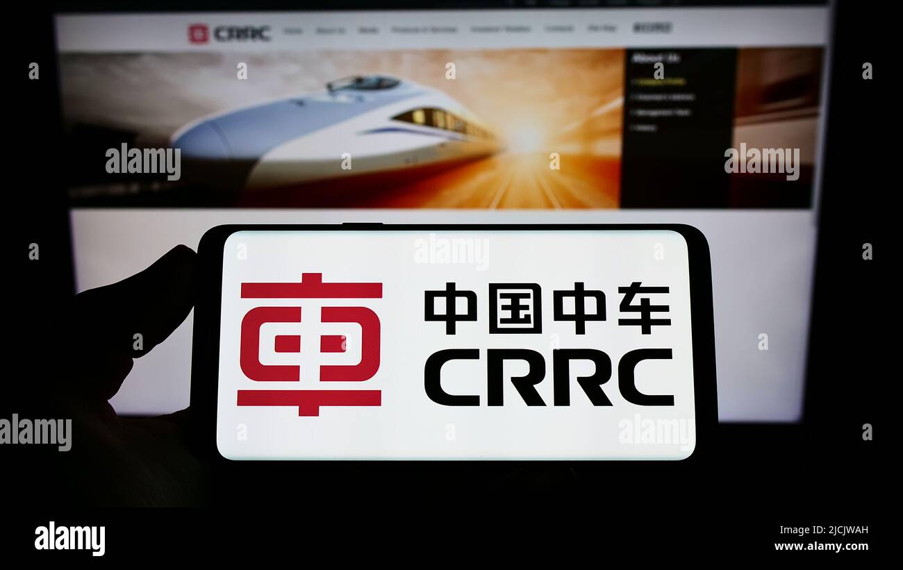 Persona che tiene lo smartphone con il logo della società cinese CRRC Corporation Limited sullo schermo di fronte al sito web. Mettere a fuoco sul display del telefono. Foto Stock