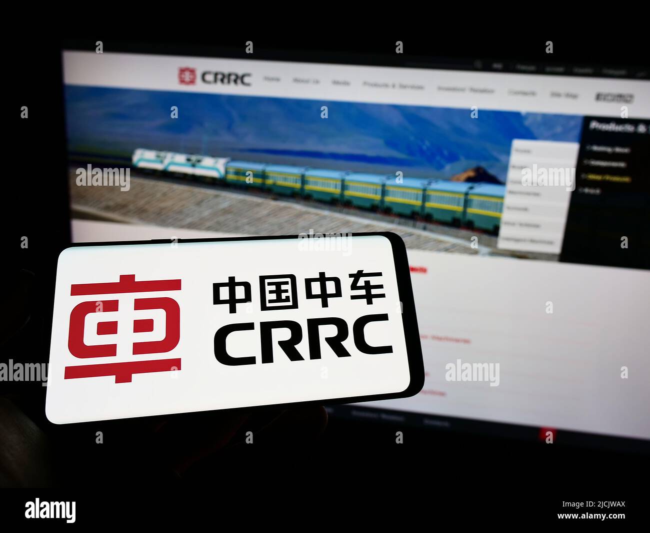 Persona che tiene il cellulare con il logo della società cinese CRRC Corporation Limited sullo schermo di fronte al sito web aziendale. Mettere a fuoco sul display del telefono. Foto Stock