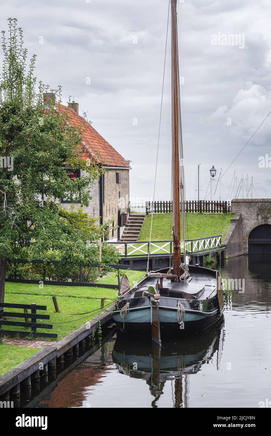 Enkhuizen, Paesi Bassi - Agosto 18,2021: Tradizionale barca da pesca olandese con pittoreschi cottage di pescatori sullo sfondo nella città storica o Foto Stock