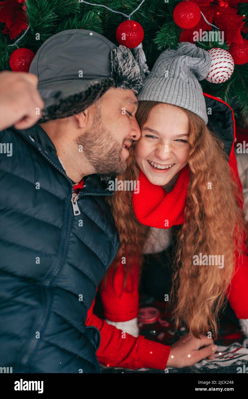 Felice famiglia amorevole, Padre bacia la figlia adolescente e abbraccia all'aperto. Cute redhaired bambino e papà hanno divertimento nel bagagliaio dell'automobile. Foto Stock