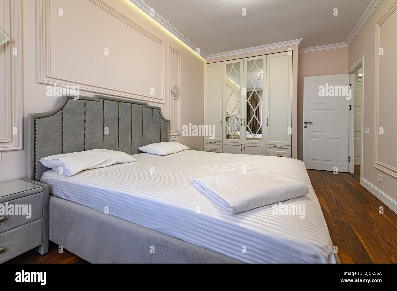 Camera da letto moderna beige e marrone con letto matrimoniale Foto Stock