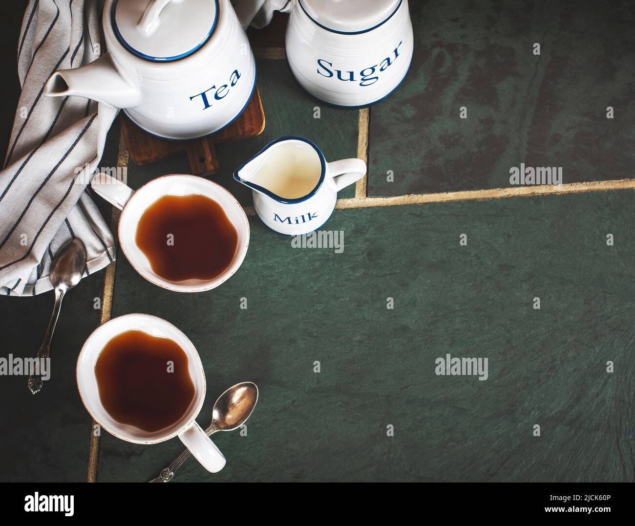 Due tazze di tè, teiera, latte sul tavolo, spazio copia. Foto Stock