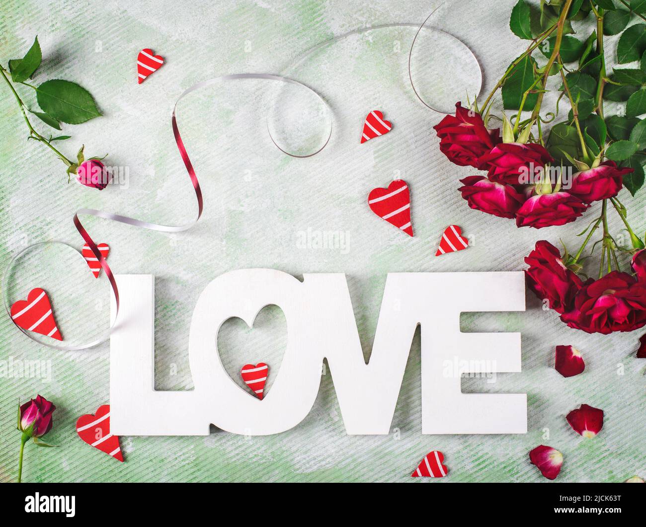 Festa composizione di amore per San Valentino fatta di rose rosse, cuori e parola Amore. Disposizione piatta. Foto Stock