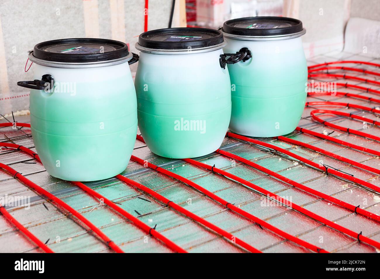 Montaggio dell'impianto di riscaldamento a pavimento. Interno di un nuovo edificio residenziale. Tubi riempiti con glicole propilenico da lattine. Riscaldamento autonomo Foto Stock