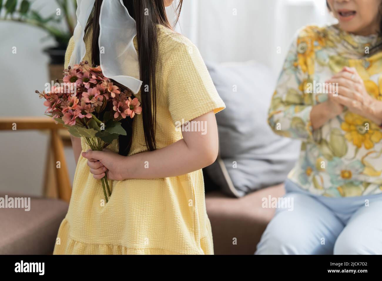 Momento felice di piccola figlia sorprendere la sua madre amorevole in vacanza dando fiori Foto Stock