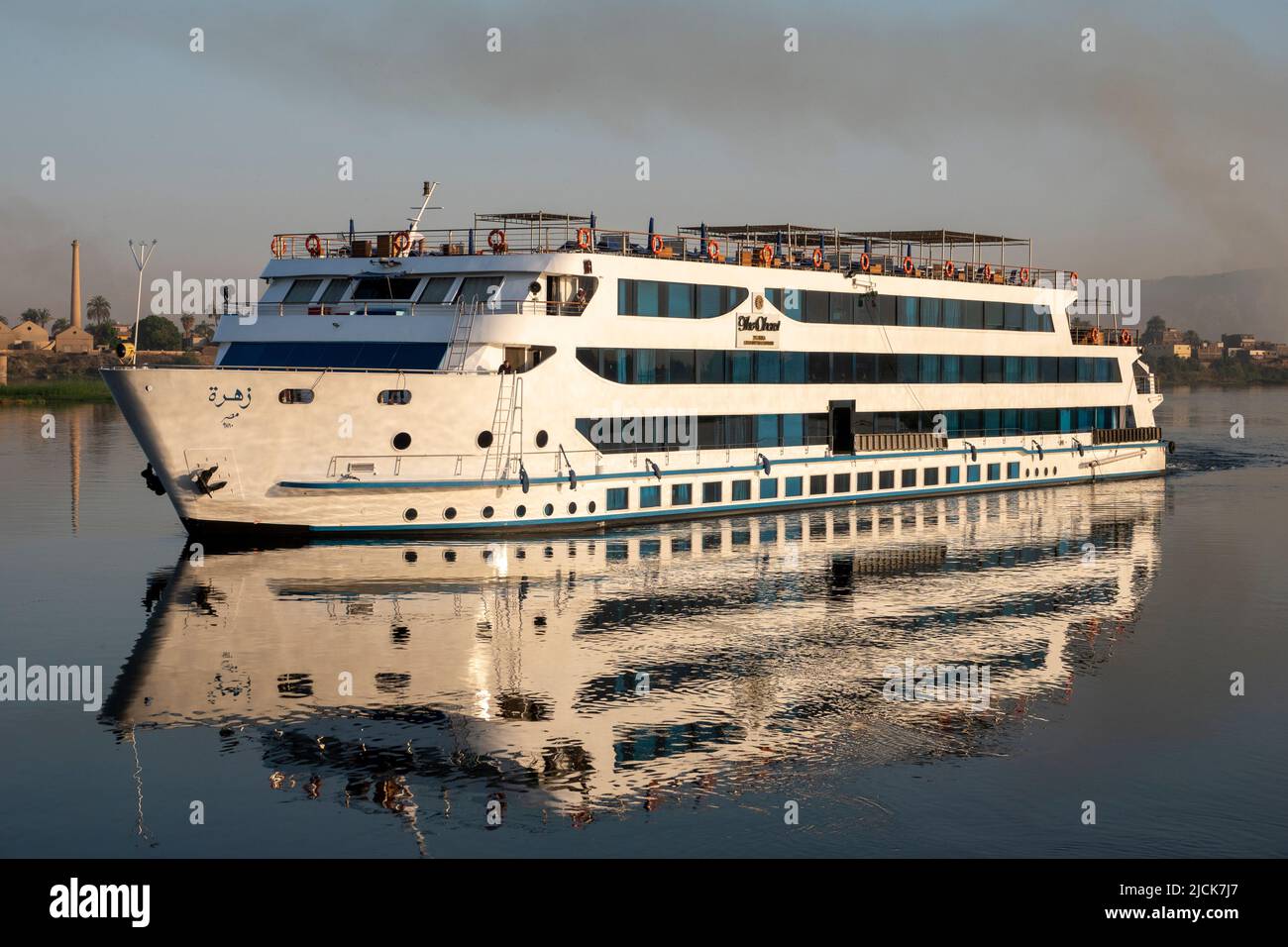 Crociera sul Nilo in barca a vela sulle acque calme con riflessi nella luce del mattino presto Foto Stock