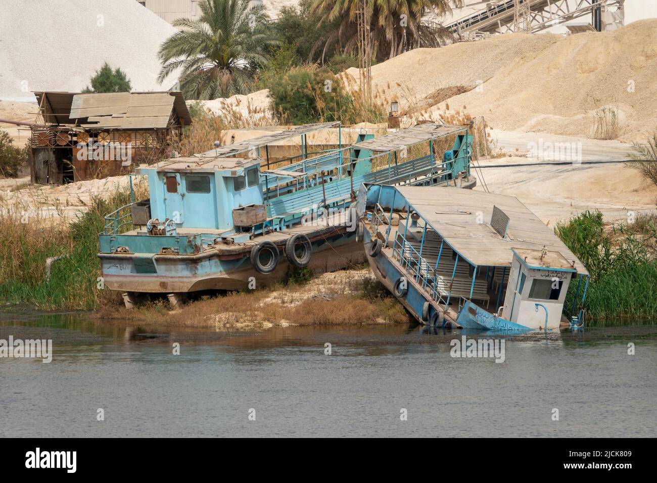 I traghetti passeggeri locali abbandonati del Nilo sono saliti sulla fangosa riva del fiume Foto Stock