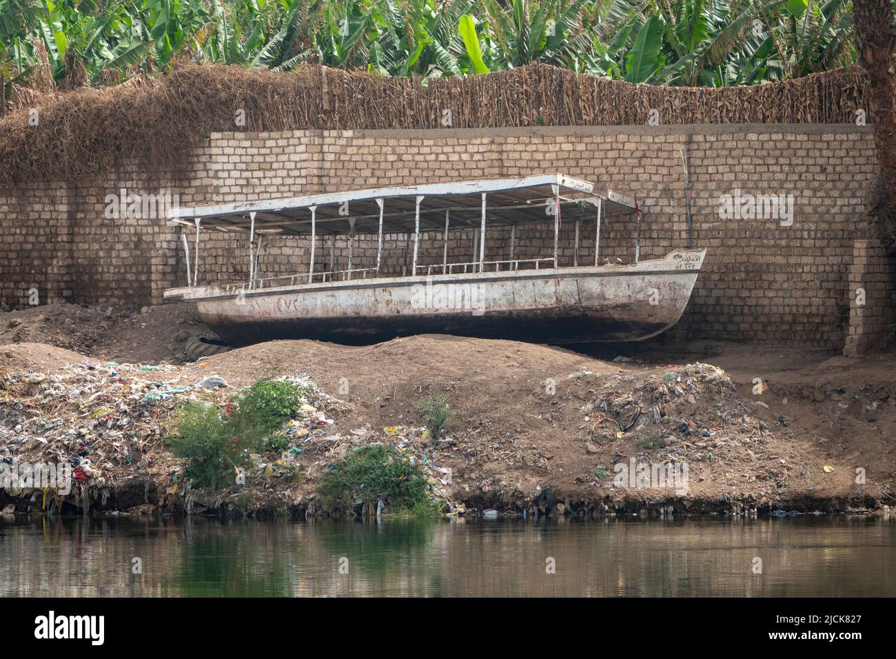 I traghetti passeggeri locali abbandonati del Nilo sono saliti sulla fangosa riva del fiume Foto Stock