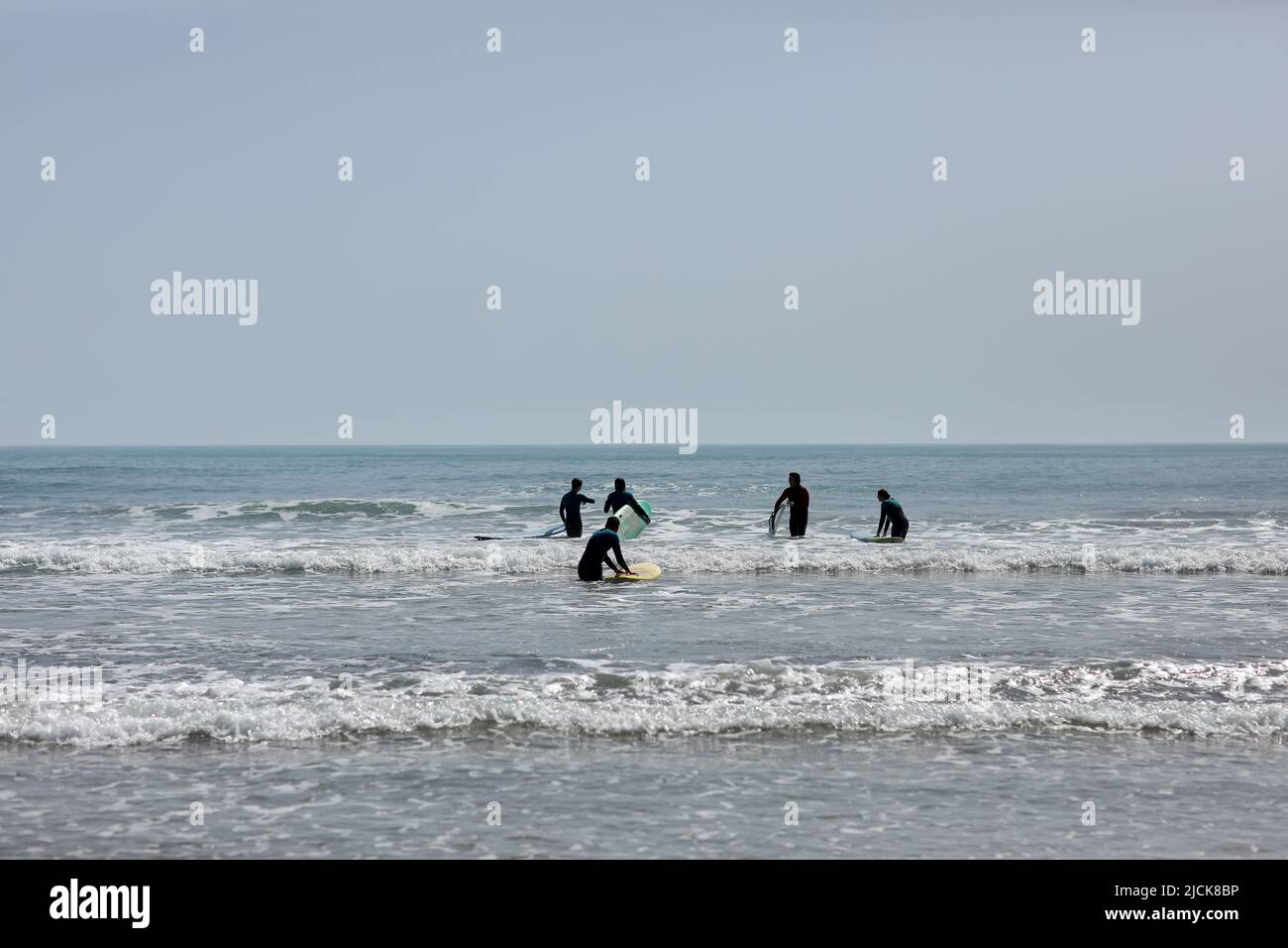 Spagna-Castellon, 16 aprile 2022: Gruppo di persone che imparano a nuotare su una tavola da surf sul Mar Mediterraneo. Foto Stock