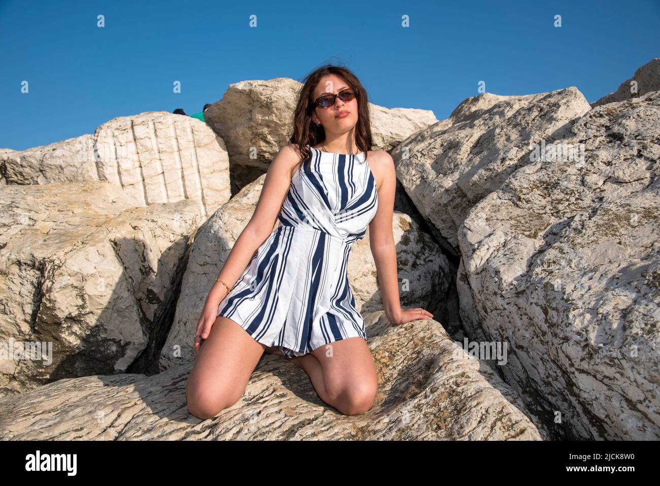 Ragazza teenegers vestita alla moda che si rilassa sul lungomare Foto Stock