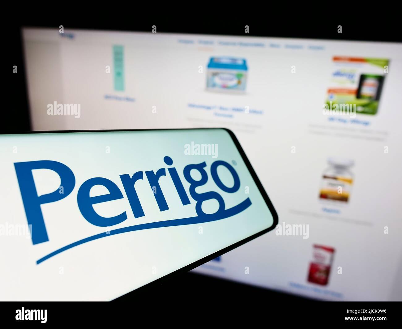 Telefono cellulare con logo del produttore farmaceutico Perrigo Company plc sullo schermo di fronte al sito web. Concentrarsi sul centro del display del telefono. Foto Stock