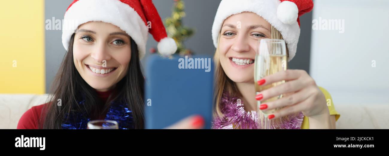 Sorelle allegre che fanno selfie su smartphone con bicchieri da champagne Foto Stock