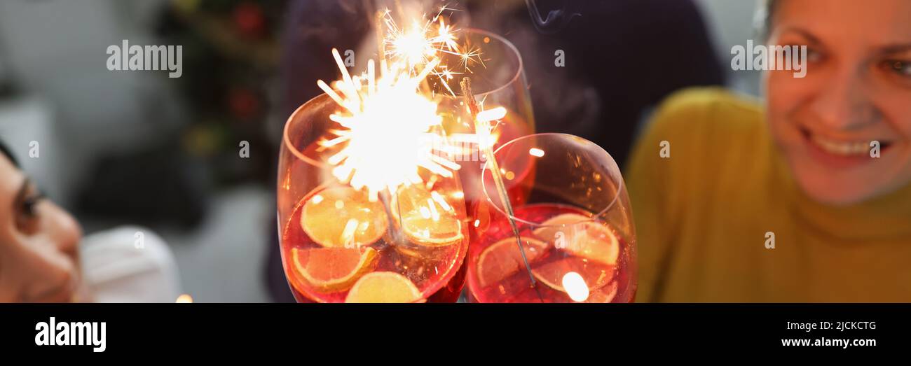 Amici che festeggiano l'anno nuovo alzando gli occhiali e fare brindisi Foto Stock
