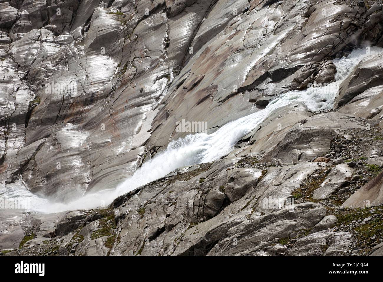 Fonte del fiume Rodano, acqua ruvida caduta tra rocce di montagna. Paesaggio delle alte alpi di terreno arido con cascata. Foto Stock