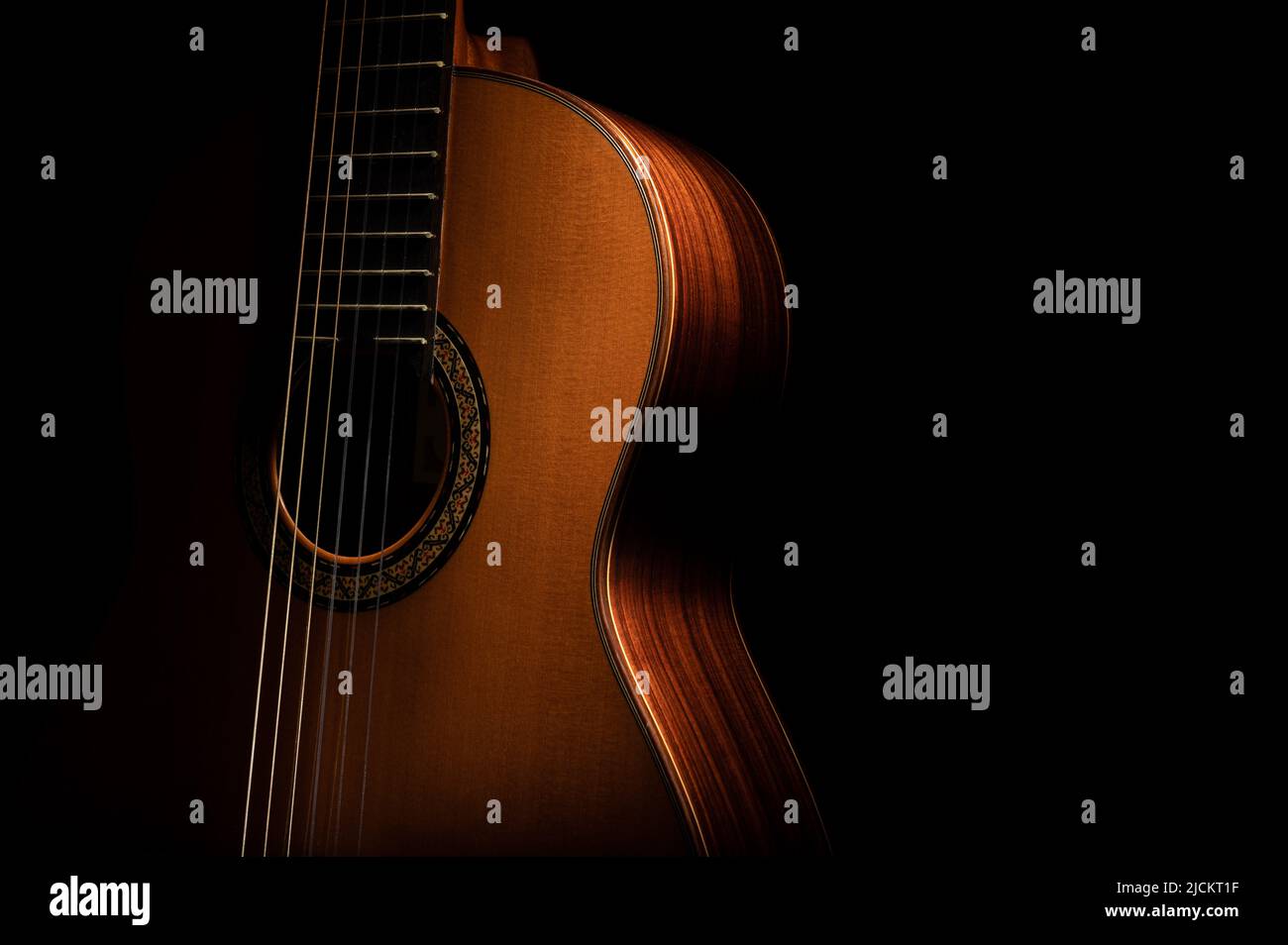 Chitarra classica su sfondo nero con spazio negativo per la copia Foto Stock