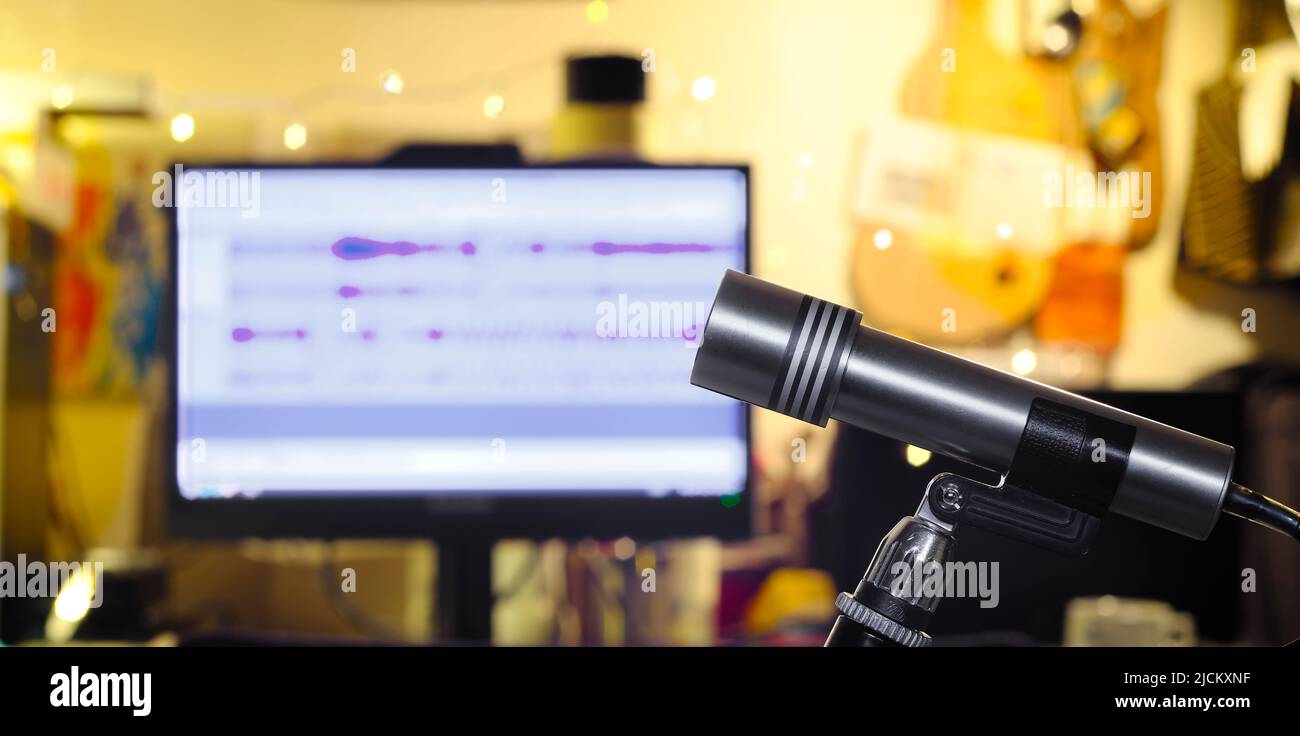 Concetto di podcasting, microfono di registrazione vintage e ambiente di lavoro disordinato su sfondo sfocato Foto Stock