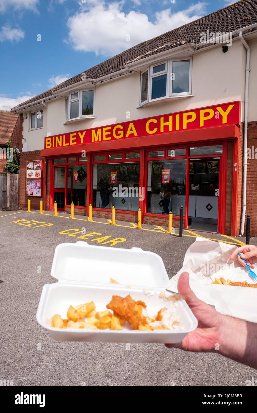 Binley Mega Chippy, Coventry, come visto in un video virale TikTok, con le mani che tengono chip in primo piano Foto Stock