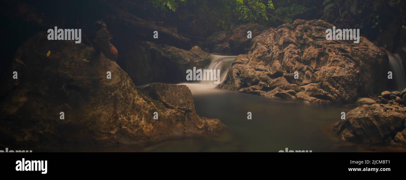 Foto dell'acqua che scorre tra le rocce nel fiume Lamsujen, Aceh, Indonesia. Foto Stock