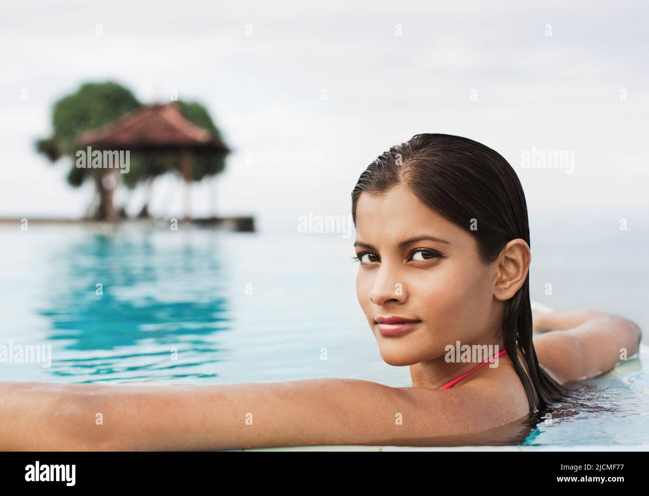 La donna si rilassa nella piscina Infinity presso Saman Villas. Aturuwella, Bentota, Sri Lanka. Foto Stock