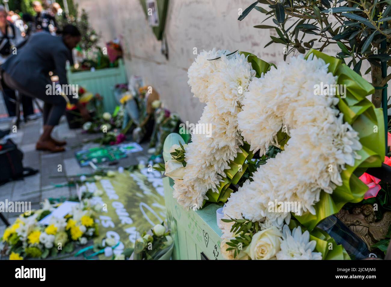 Londra, Regno Unito. 14th giugno 2022. La gente porta fiori (alcuni ci ricordano che 72 persone sono morte) mentre visitano il muro commemorativo nel quinto anniversario del disastro della Torre di Grenfell. La gente del posto rimane sconvolta e frustrata dal fatto che nessuno è stato chiamato a rendere conto della tragedia. Credit: Guy Bell/Alamy Live News Foto Stock