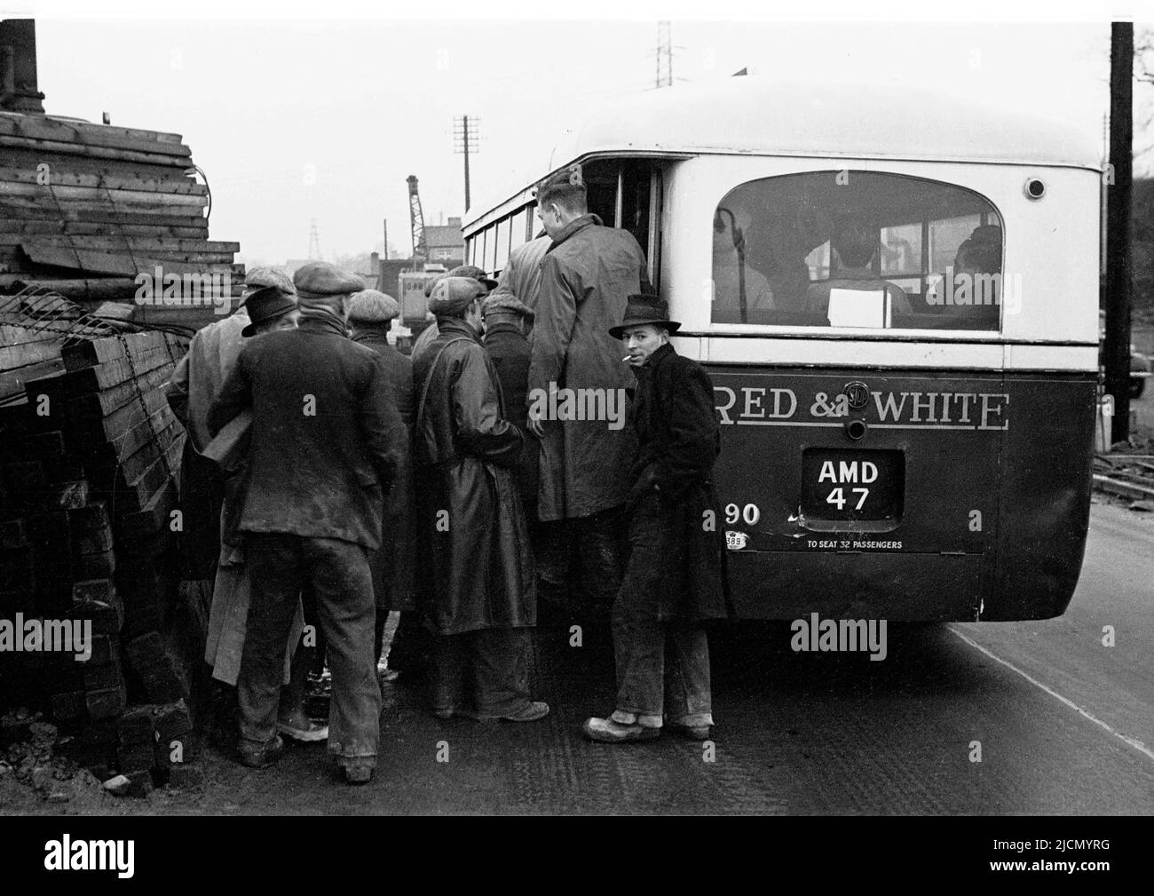 1950s, storici, operai di stoffa capeggiato da una fabbrica vicino Trehafod, Galles del Sud che ottiene su un autobus rosso & bianco dopo la conclusione del turno di una giornata. Fondata nel 1929, Red & White Services è stata una famosa compagnia di autobus che opera in tutto il Galles del Sud in quest'epoca. Foto Stock