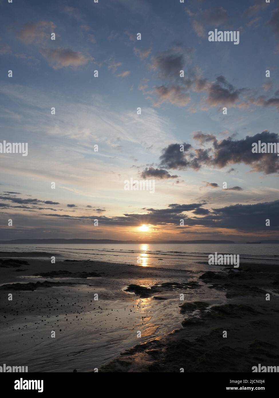 Un mix di nuvole al tramonto in una serata estiva a Nairn Beach. Vista verso la Black Isle. Foto Stock