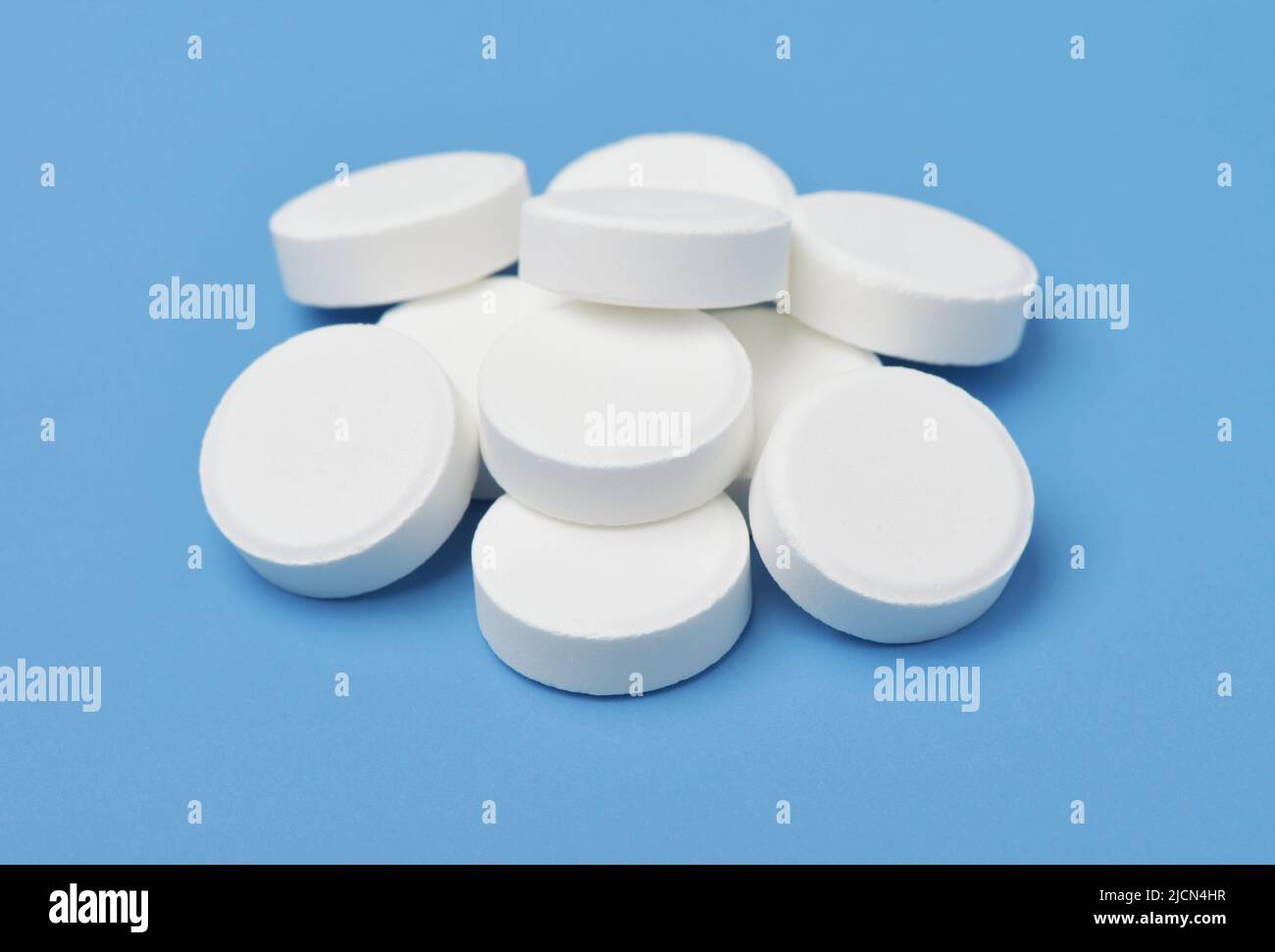 Gruppo di pillole mediche bianche isolato su sfondo blu Foto Stock