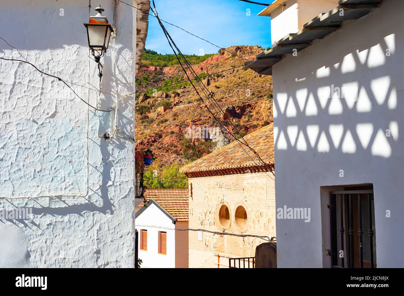Strada di un vecchio villaggio di montagna al sole, ombre sul muro, Cartagena, Spagna Foto Stock
