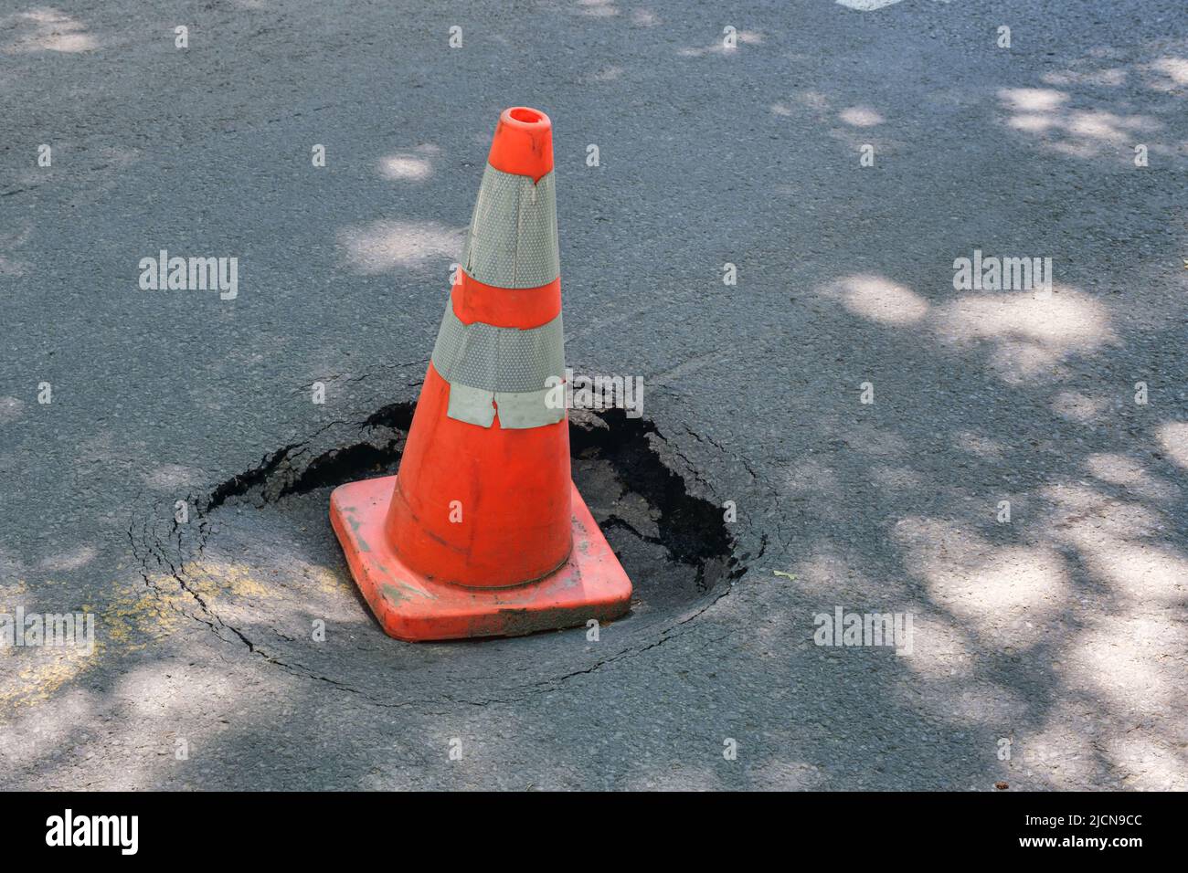 Grande pothole arrotondata a Montreal con cono di traffico Foto Stock