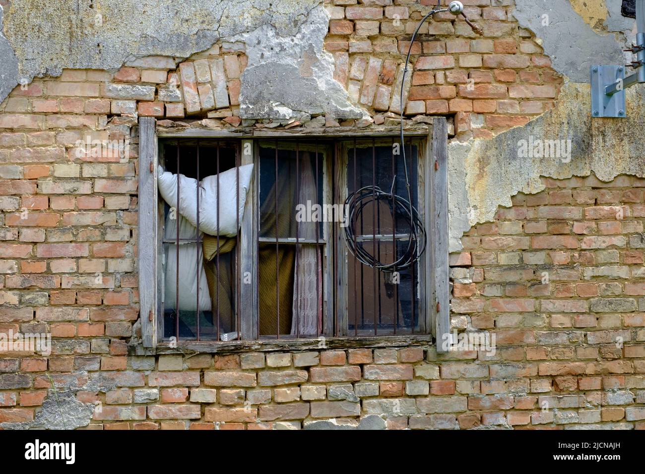 cornice finestra di legno marcio con vetro mancante incastonata nel muro di una casa sminuzzata trascurata in bisogno di ristrutturazioni lente zala contea ungheria Foto Stock