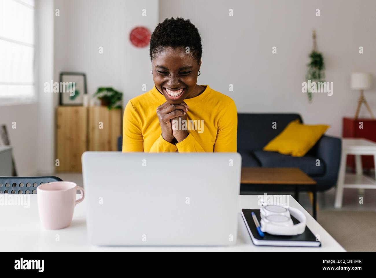 Giovane donna africana eccitata che festeggia il successo guardando lo schermo del laptop Foto Stock