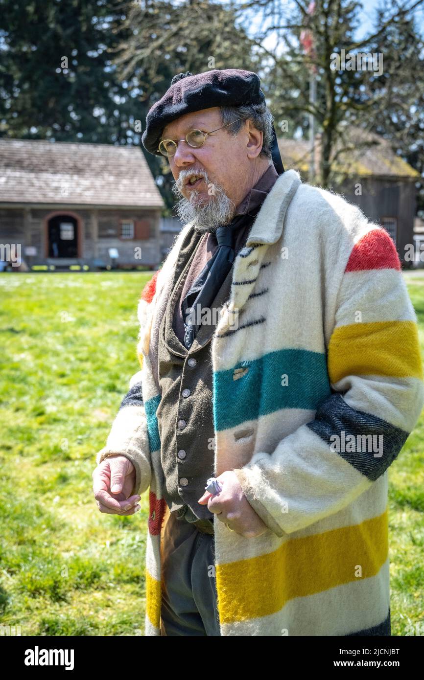 Guida e reenactment volontario indossare un cappotto che sarebbe stato indossato da uomini alla Hudson Bay Company a Fort Nisqually, Tacoma, Washington Foto Stock