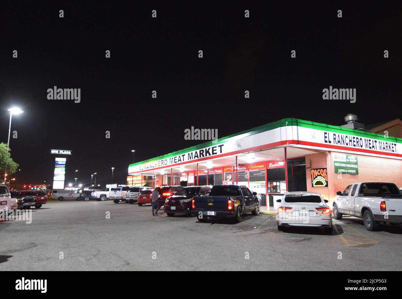 Auto parcheggiate fuori dal mercato di carne di El Ranchero di notte a Irving Texas Foto Stock