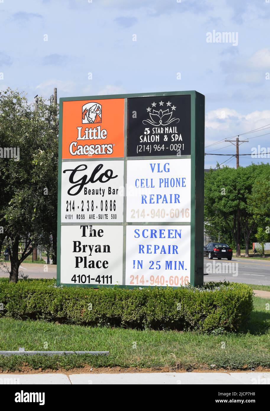 Strip Mall Sign con negozi e ristoranti, tra cui Little Caesars, un negozio di riparazione cellulari, Glo Beauty Bar, e un parrucchiere/estetista e spa Foto Stock