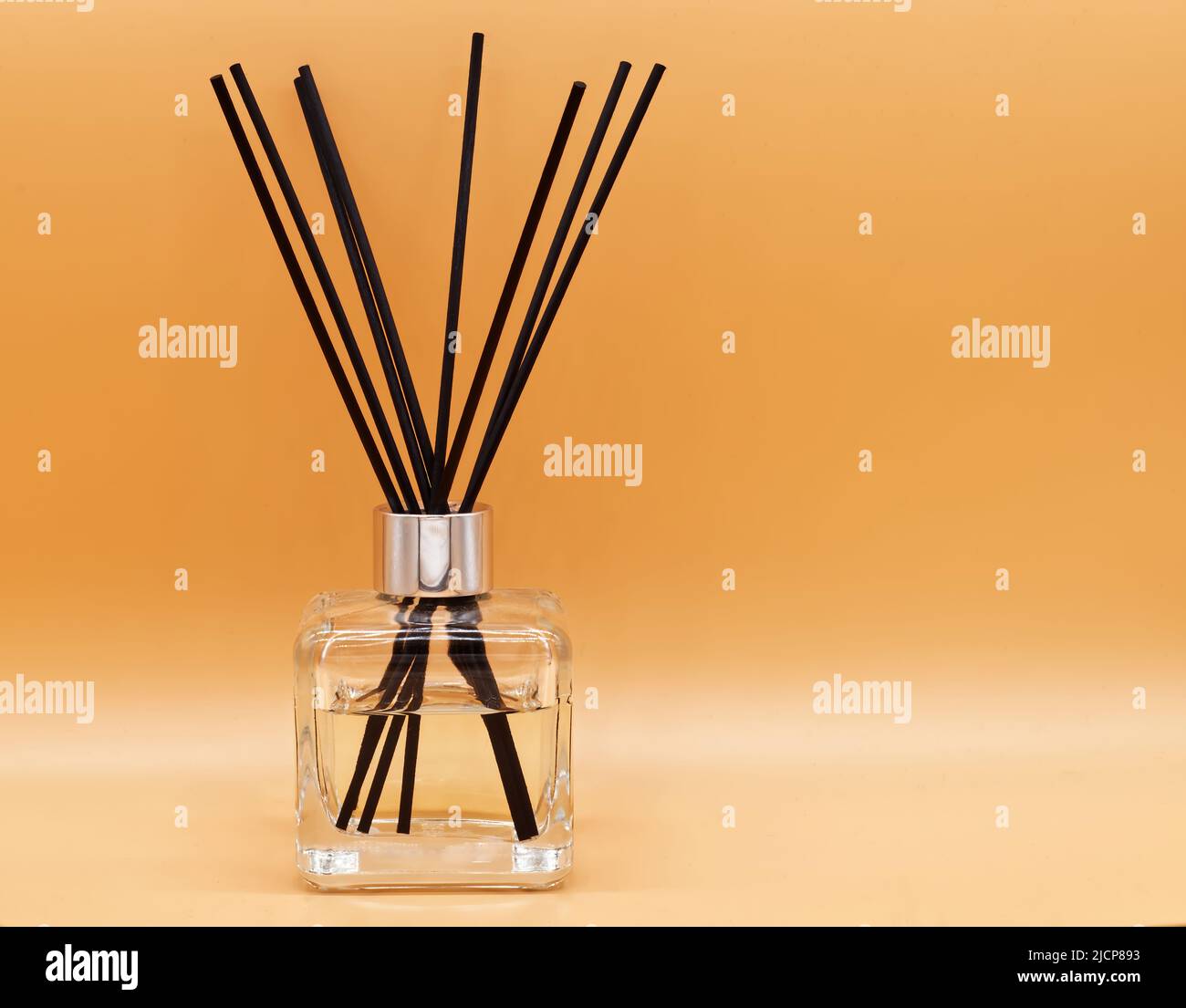 Deodoranti per ambienti isolati su sfondo beige. Bastoncini aromatiche e bottiglia d'olio essenziale per il relax Foto Stock