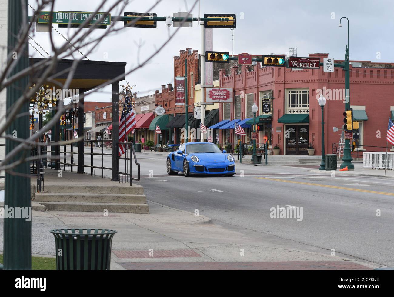 Una Porsche GT3RS blu brillante guida lungo Main Street a Grapevine Texas Foto Stock