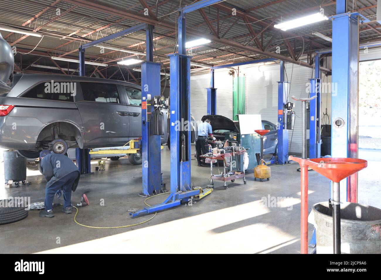 Un meccanico auto lavora su un'auto in un negozio di riparazione auto all'estero Foto Stock
