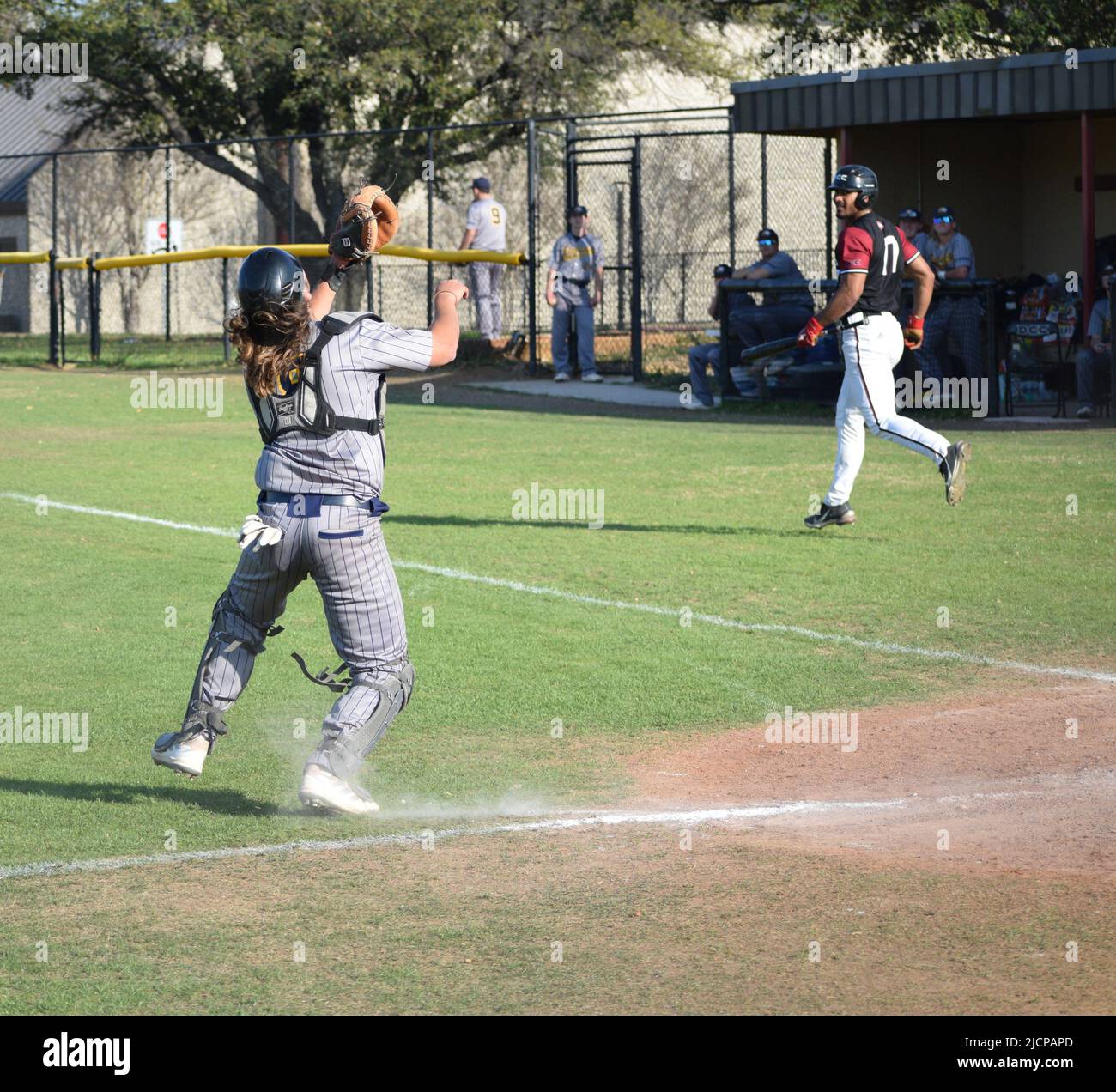 Un catcher di baseball dell'Ecclesia College che si prepara a catturare un pop up colpito da un giocatore di baseball del Dallas Christian College Foto Stock