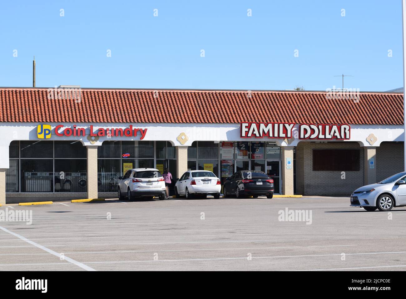 Auto parcheggiate di fronte a una lavanderia automatica e a un negozio Family Dollar Foto Stock